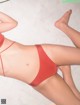 A woman in a red bikini laying on the floor.