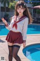 a woman in a school uniform posing by a pool