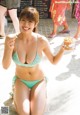 A woman in a bikini holding a cup of popcorn.