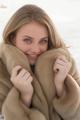 A woman in a fur coat smiles at the camera.