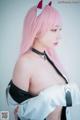 A woman with pink hair wearing a cat ears headband.
